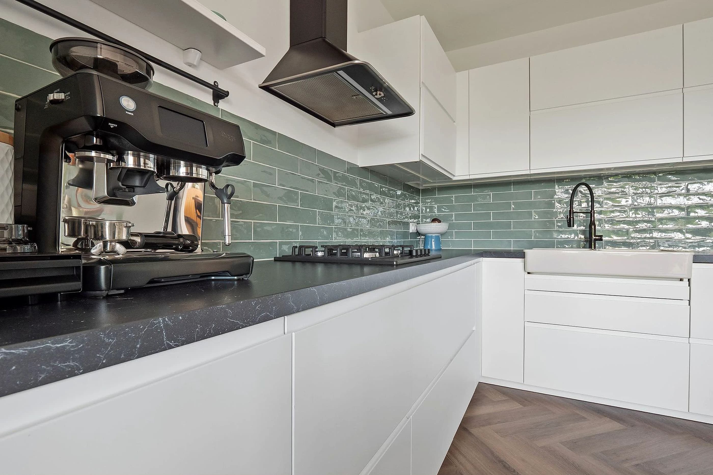 Detail van een door Renovast gemonteerde keuken met groene tegelwand